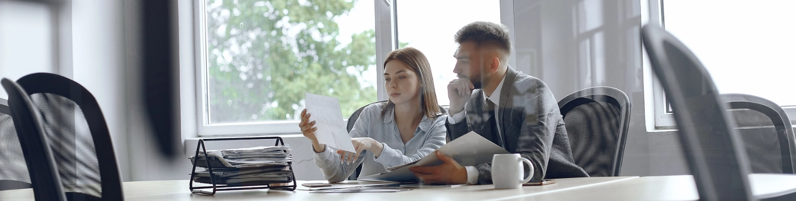 Dos empresarios discutiendo sobre documentos financieros en una oficina, ilustrando el delito de administración desleal